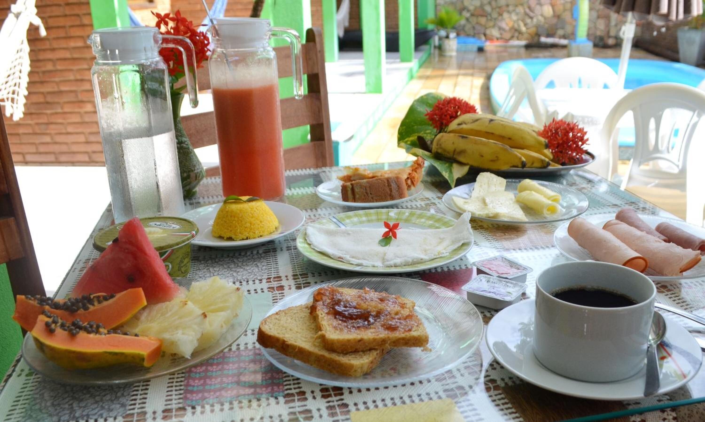 Une table dressée avec divers éléments pour le petit-déjeuner, notamment des toasts, des fruits et une tasse de café.