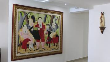A large framed painting on a wall in a hallway.