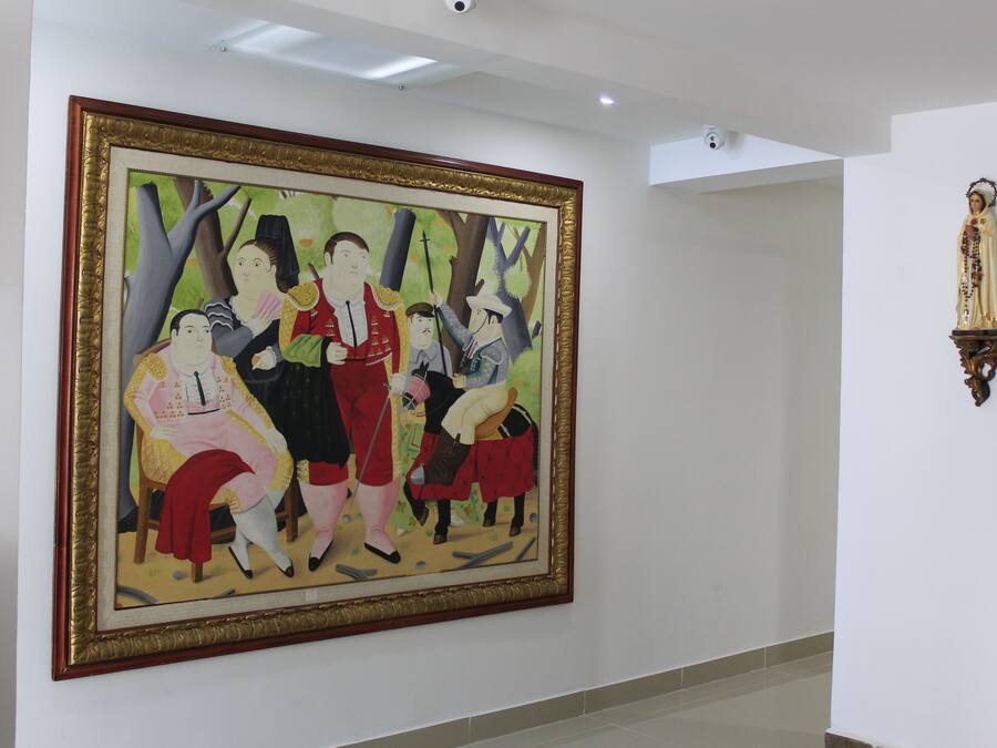 A large framed painting on a wall in a hallway.