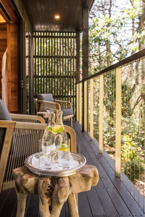 A wooden deck with a table holding a pitcher, glasses, and a tray. - Otahuna Lodge (Tai Tapu)