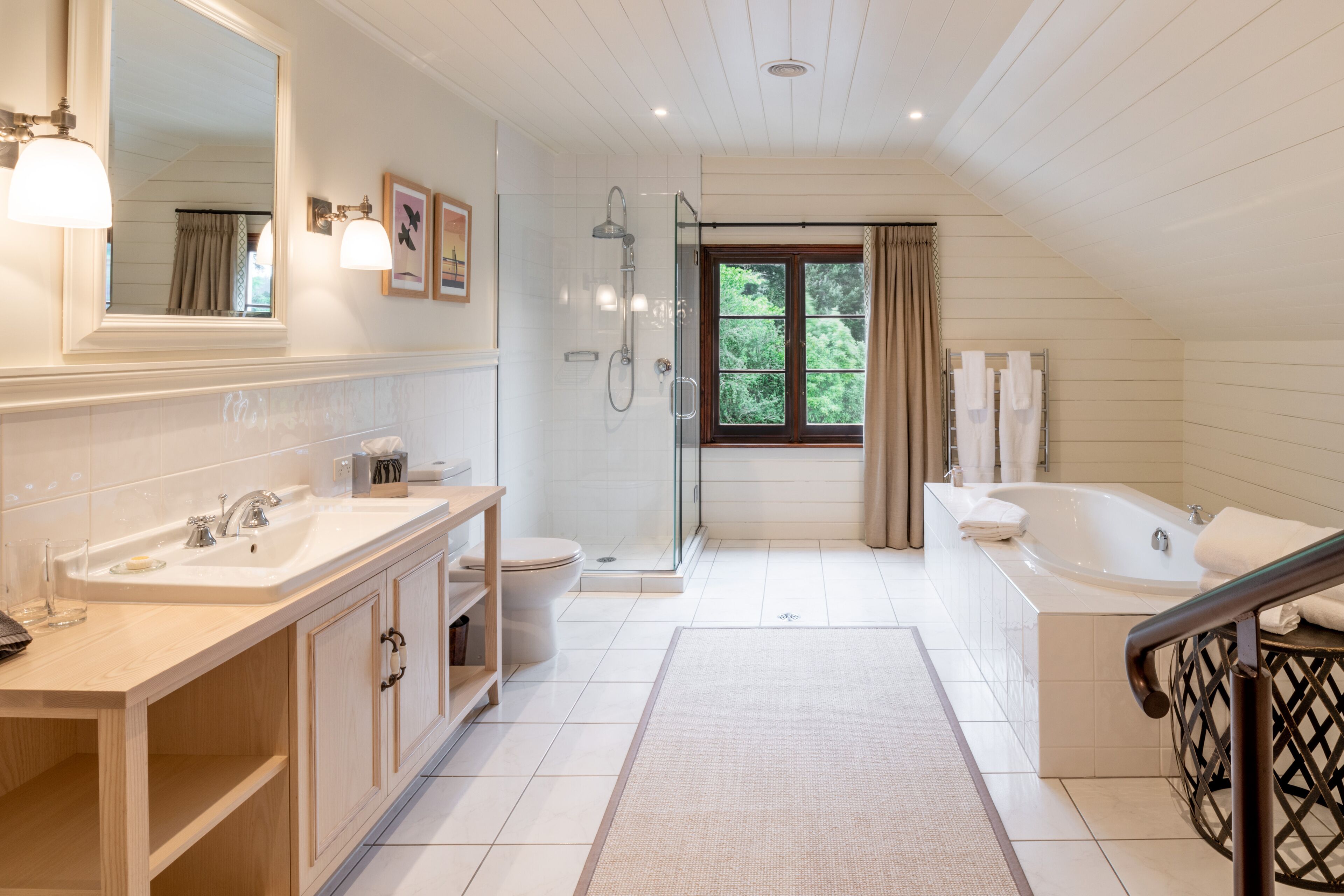 A modern bathroom with a large bathtub, a walk-in shower, and a double sink vanity.