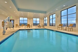 Una piscina techada, sillones reclinables de piscina