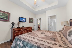 A bedroom with a bed, dresser, TV, and a door leading to another room. - Green Mountain Grand 4 Bedroom Condo by RedAwning (Branson)