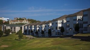 A row of white apartment buildings with a grassy area in front. - Green Mountain Grand 4 Bedroom Condo by RedAwning (Branson)