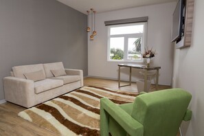 Suite, 1 cama de matrimonio grande | Sala de estar | Televisión de pantalla plana de 32 pulgadas con canales por cable