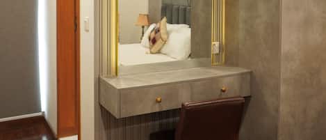 A modern bathroom with a vanity, mirror, and shower area.