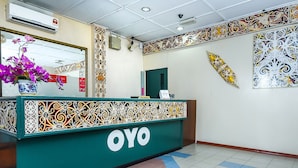 A reception desk with intricate tile patterns, a mirror above it, and a tiled floor with a geometric design.