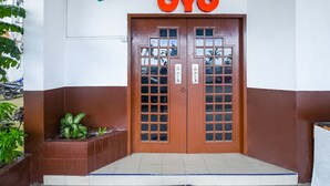 The entrance to Telang Usan Hotel with a brown door and a sign above reading "Telang Usan Hotel OYO".