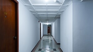 A long, narrow hallway with white walls and a tiled floor.