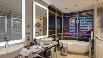 Un baño moderno con dos lavamanos, un espejo grande y una bañera.