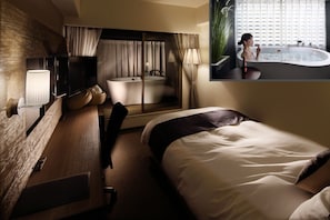 A modern hotel room with a large bed, a separate bathroom with a bathtub, a flat-screen TV, and a large window with curtains. - Hotel Gate In Kagoshima (Kagoshima)