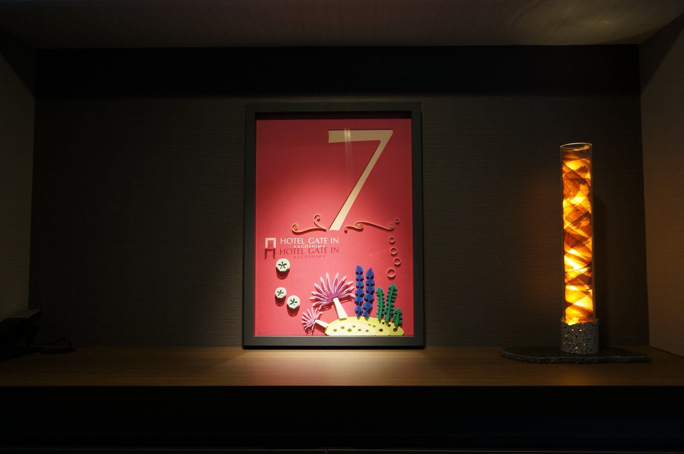 A framed number 7 sign with a hotel name and a decorative candle.