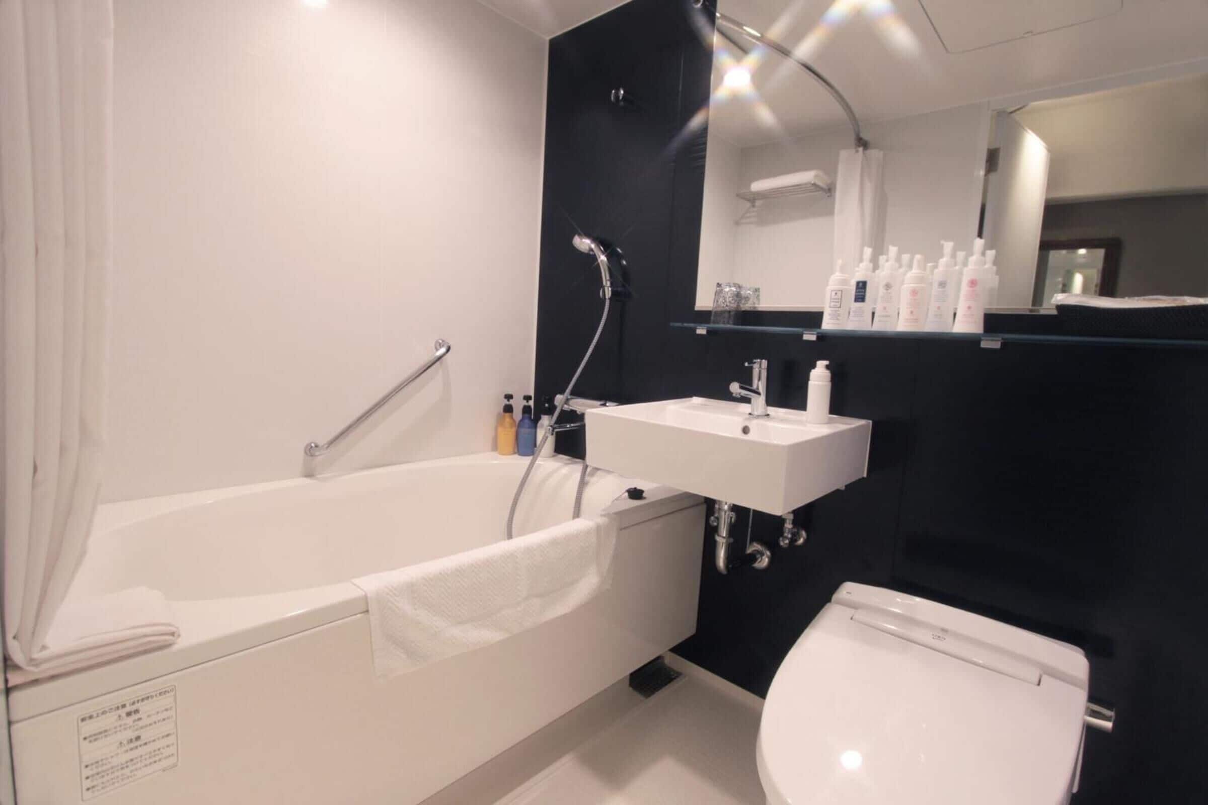 A modern bathroom with a bathtub, a sink, and a toilet.