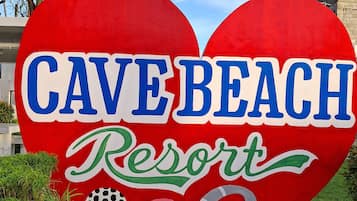 Un gran letrero con forma de corazón que muestra el texto 'CAVE BEACH Resort' y el número '00' debajo.