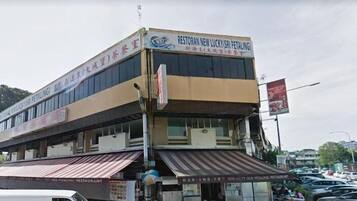 Un edificio de varios pisos con un letrero que dice 'Restoran New Lucky (Sri Petaling)'.