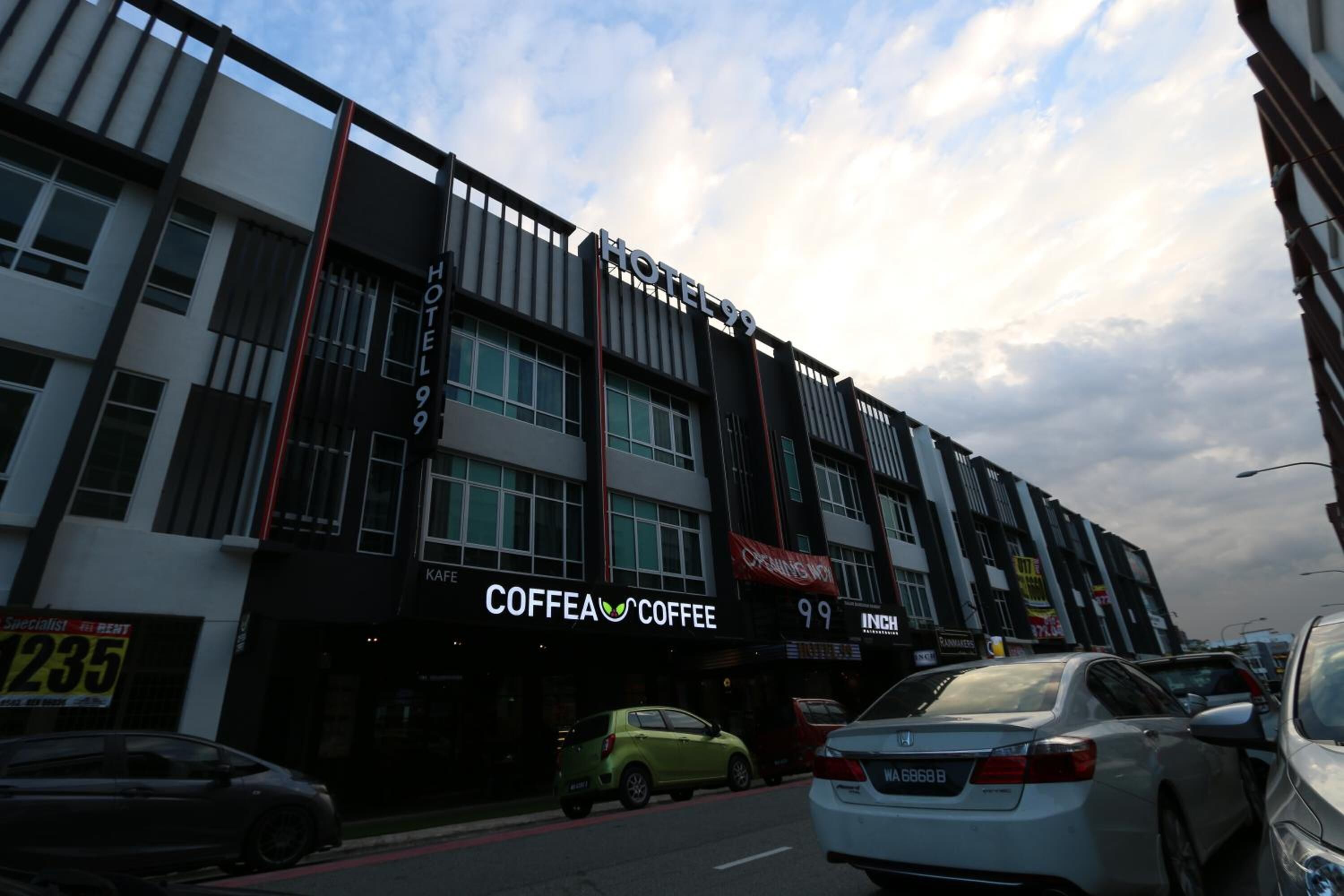 A hotel with a modern facade, multiple stories, and a prominent sign for 'HOTEL 99'.