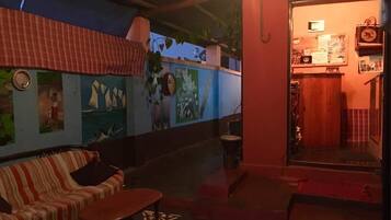 A cozy room with a striped sofa, a small table, and a mural of sailboats on the wall.
