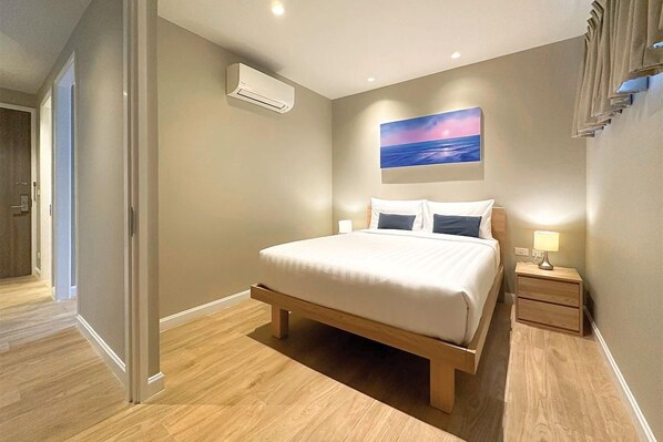 Un dormitorio con cama, mesita de noche y aire acondicionado instalado en la pared.