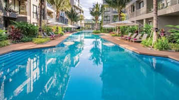 Een buitenzwembad, parasols voor strand/zwembad