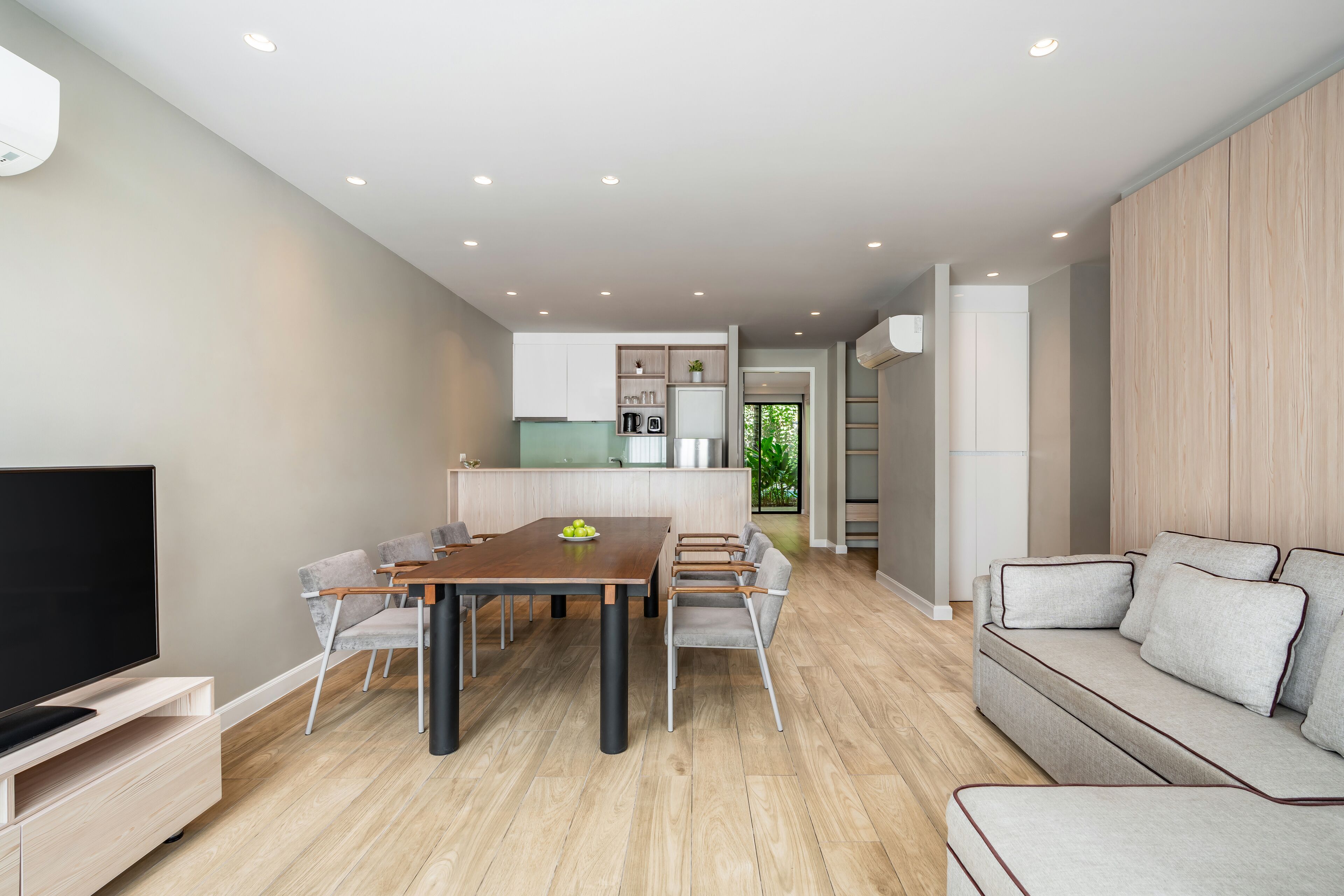 Un salon moderne comprenant un coin repas, un canapé et un téléviseur.