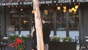 A restaurant with a sign reading "Sushi Raw Bar" and "Steaks Pasta".