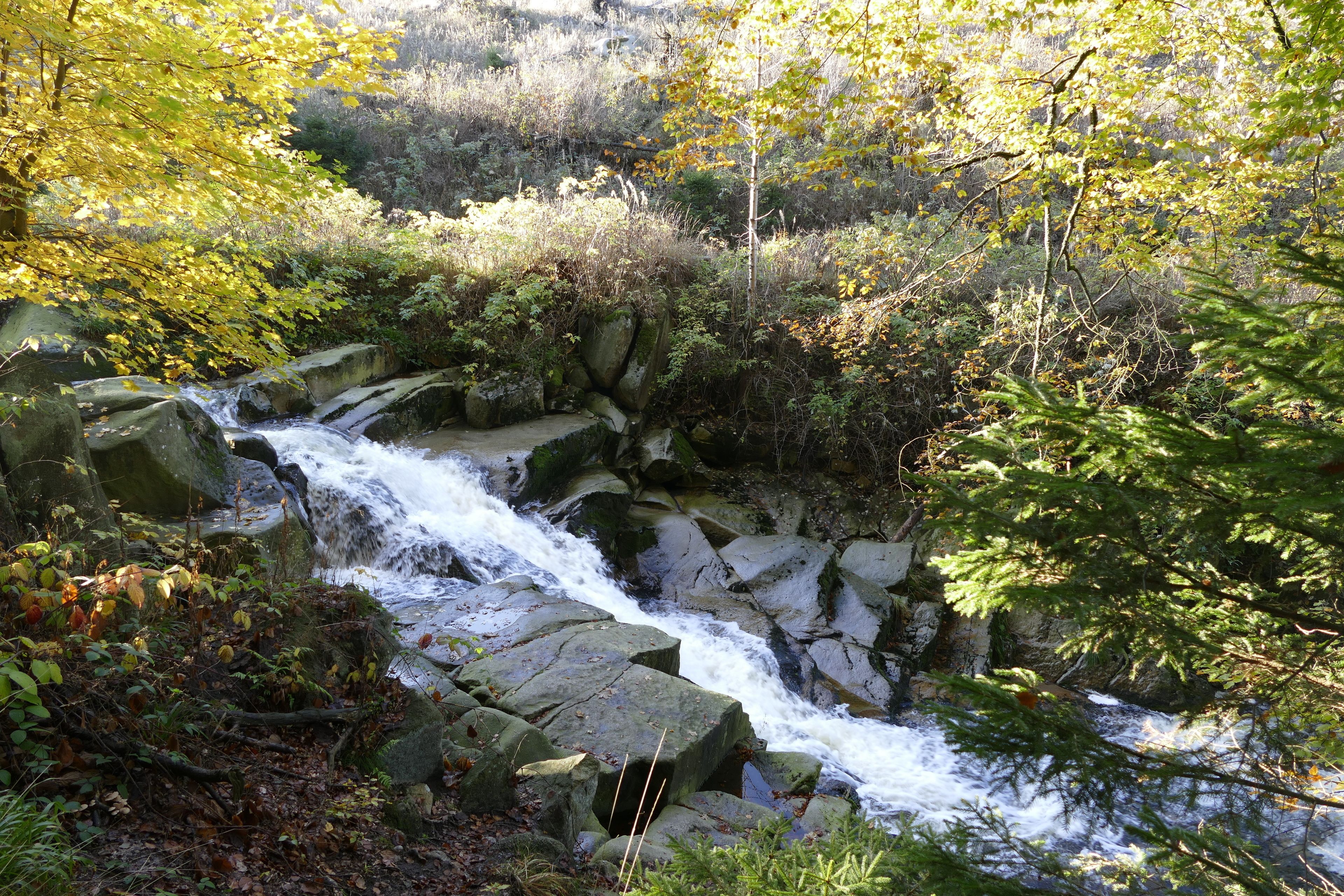 A natural waterfall surrounded by rocks and foliage.