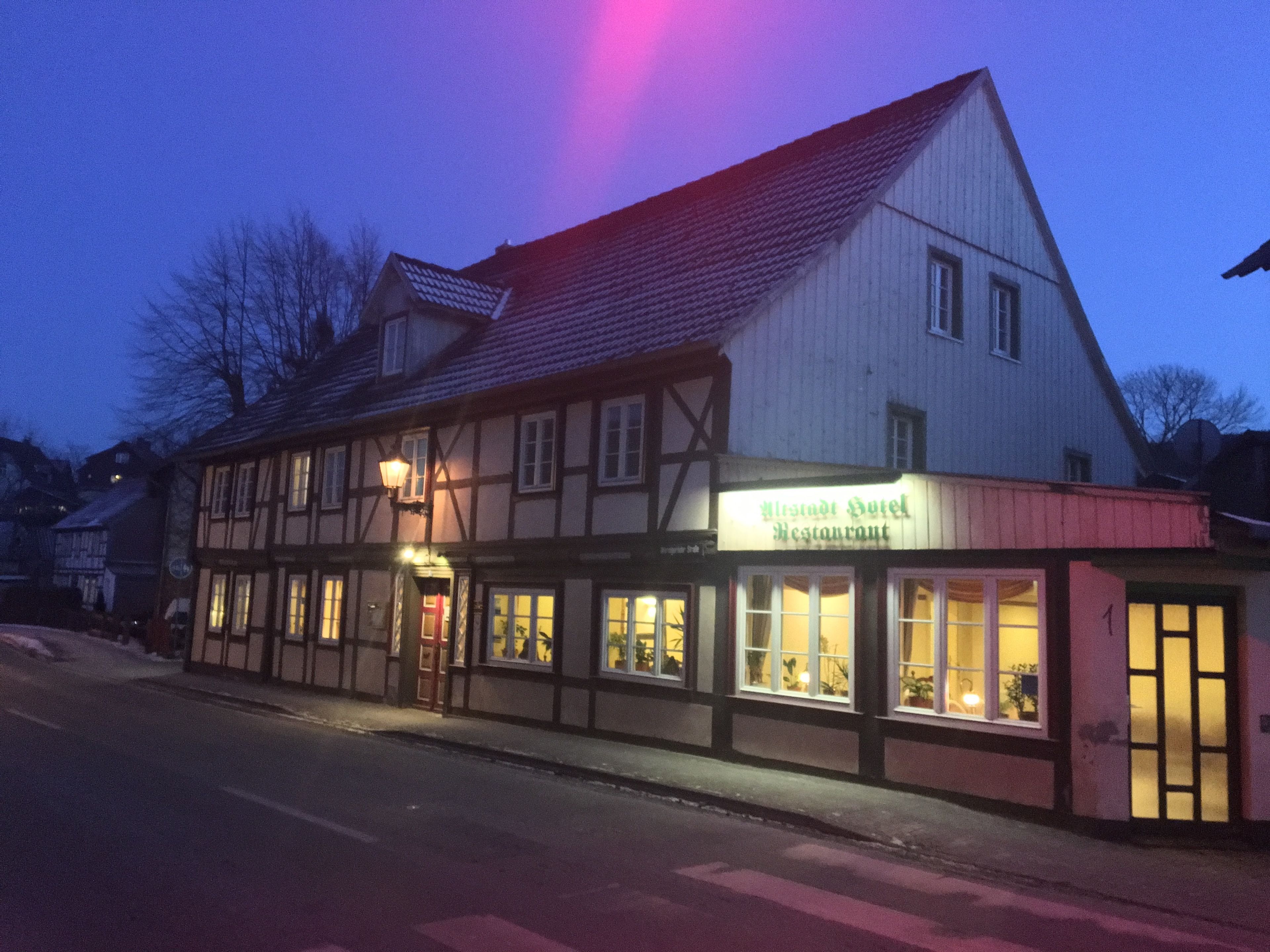 Een traditioneel vakwerkhuis met een bordje waarop 'Alster Hotel Restaurant' staat.