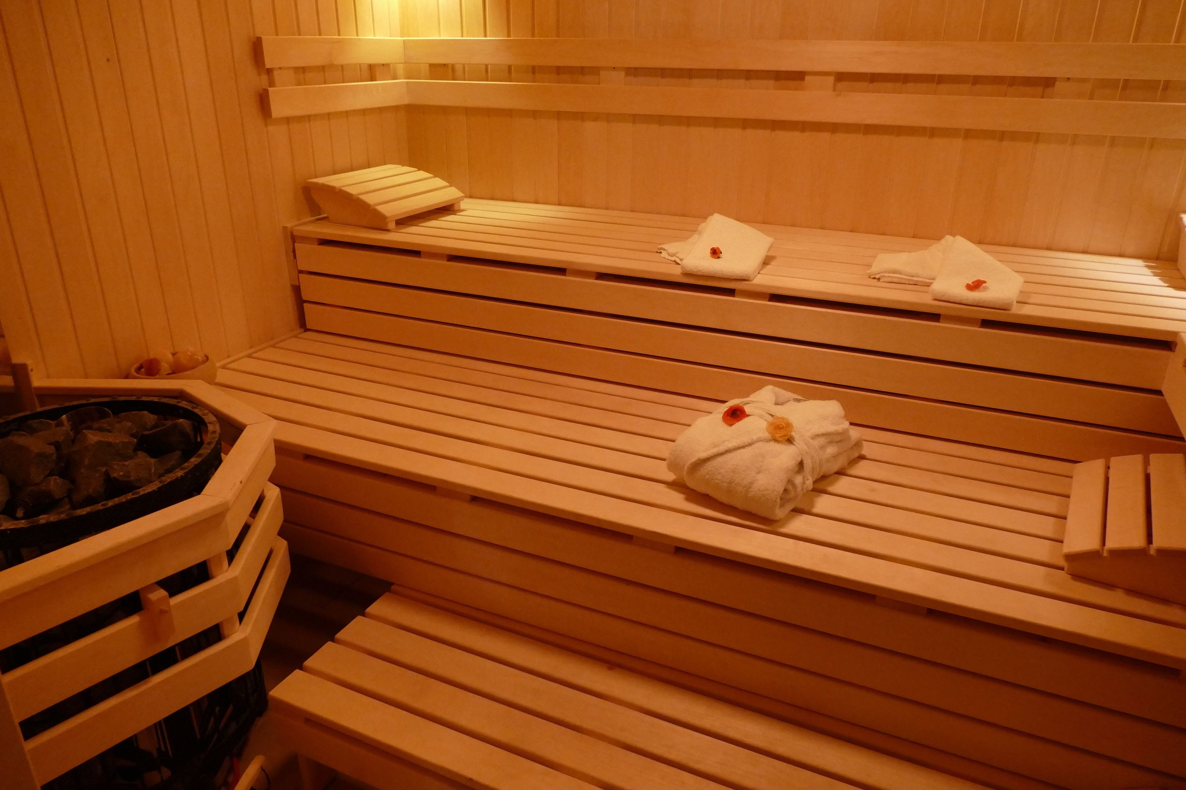 Una sauna con panche di legno, asciugamani e una panca con un asciugamano sopra.