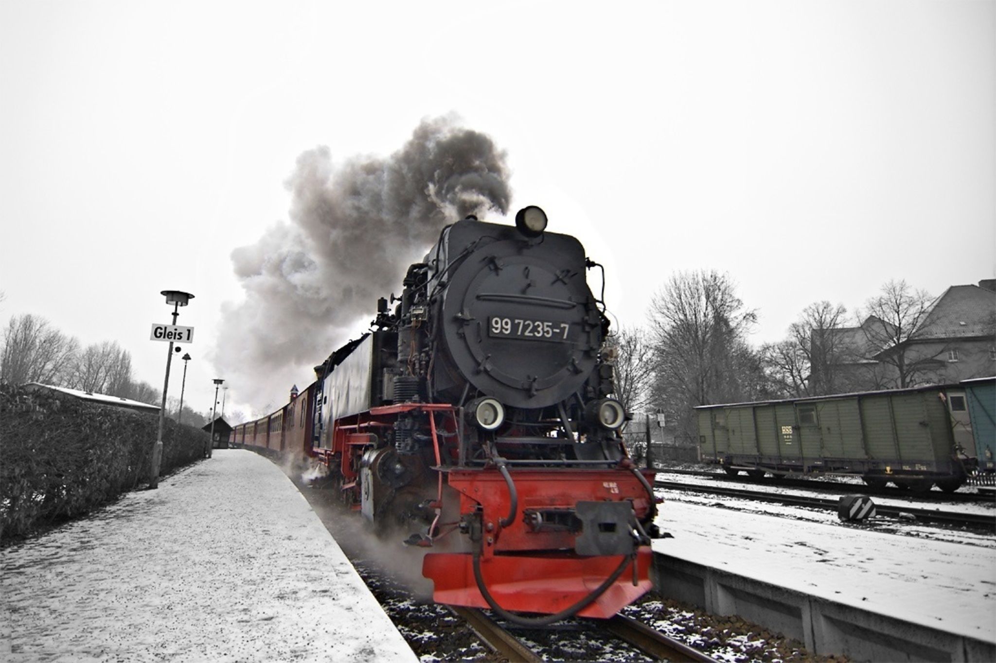 Uma locomotiva a vapor com o número 99 7235-7 em uma linha férrea coberta de neve.