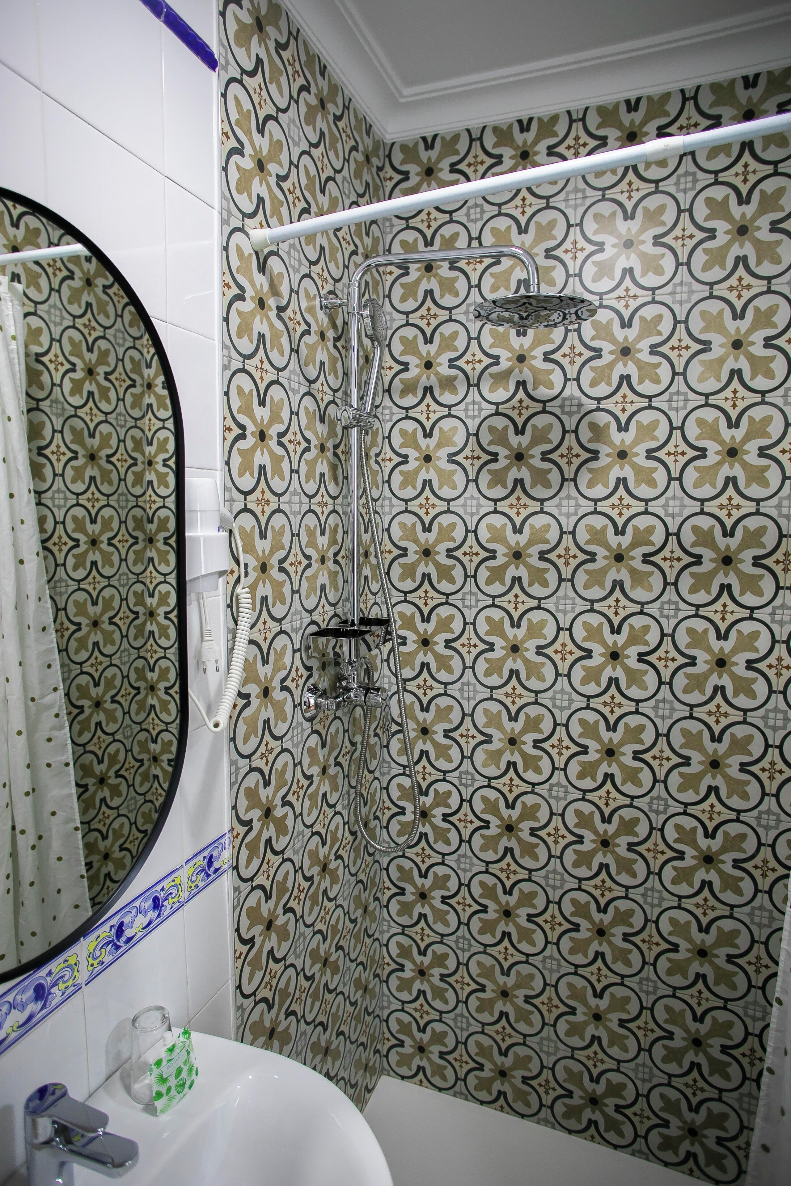 Baño con ducha, lavamanos y espejo.