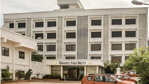 Een meerlaags gebouw met een bord waarop staat: HOTEL SRI DEVI.