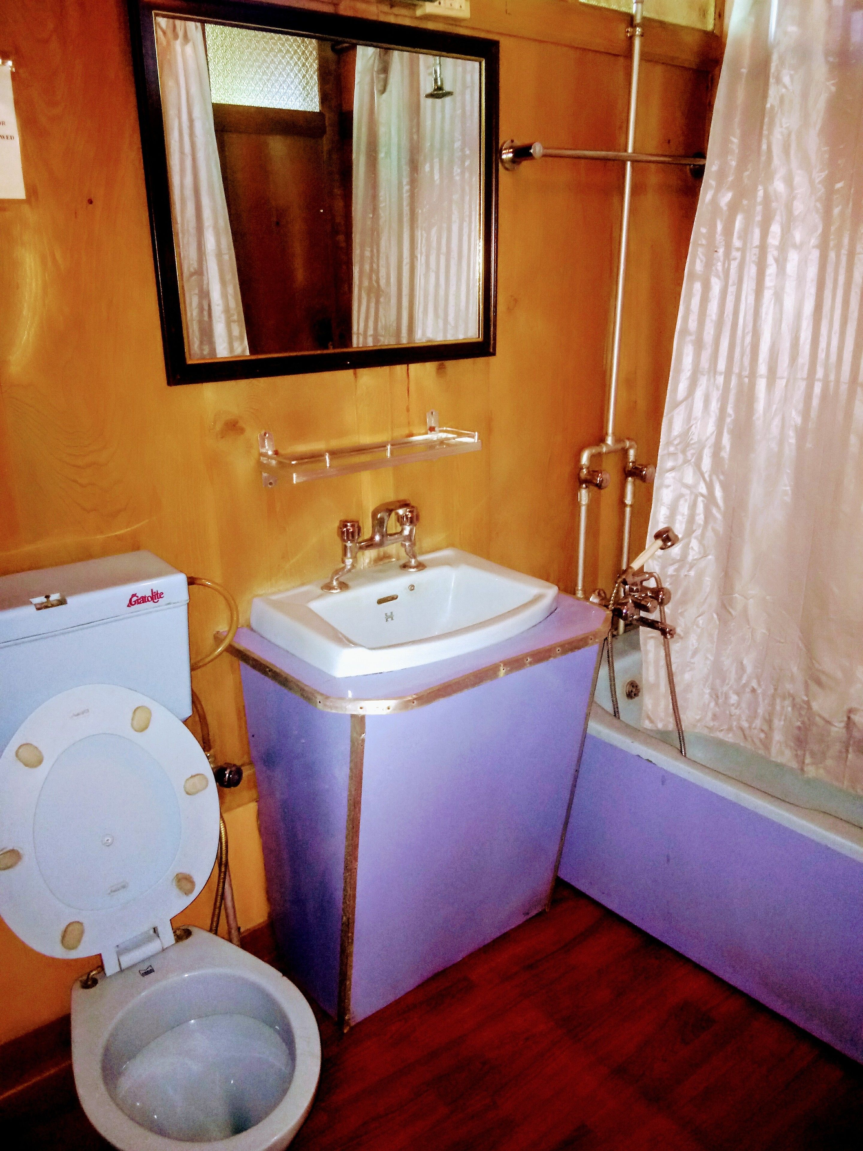 A bathroom with a toilet, sink, and shower.