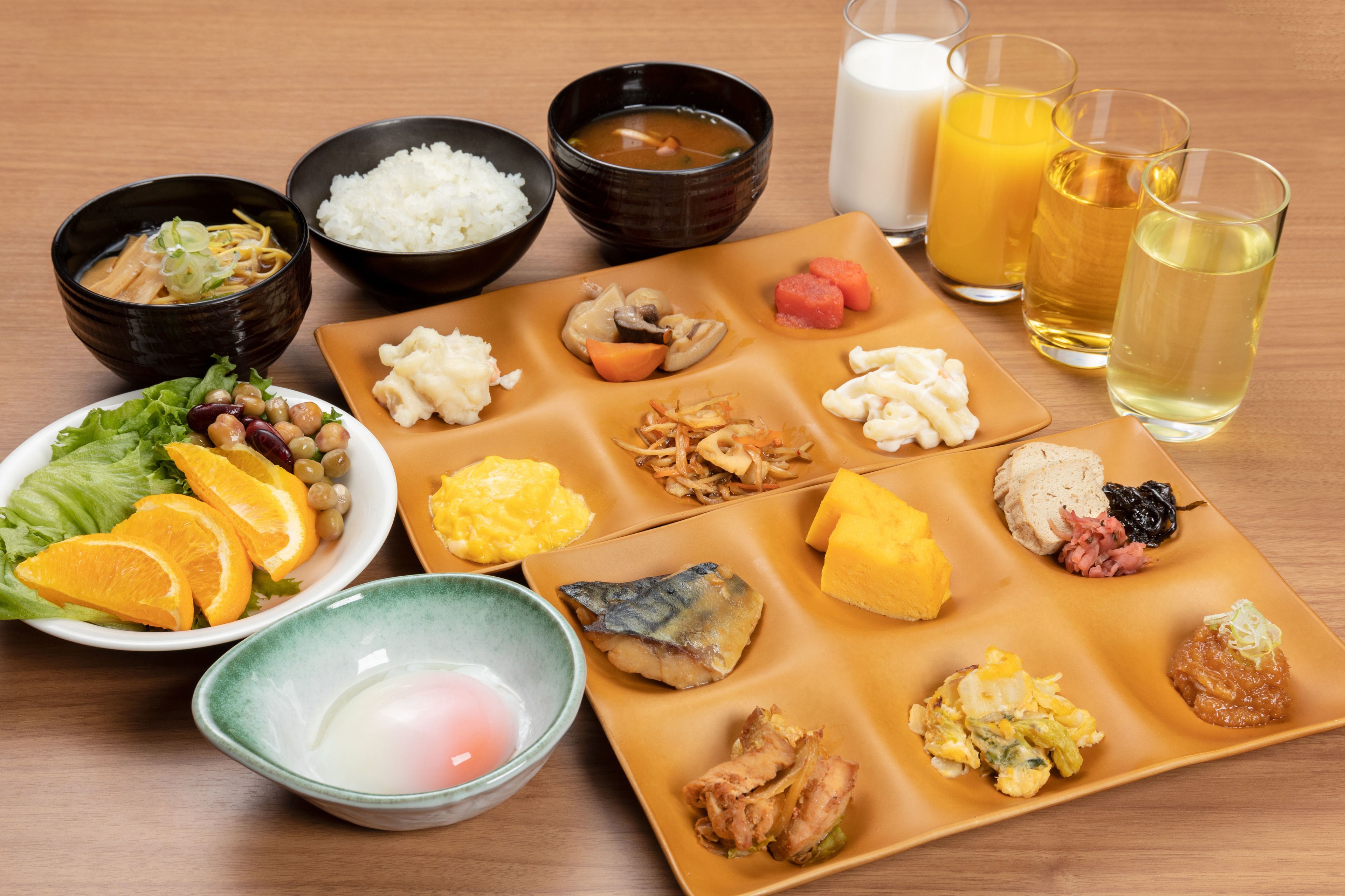 Variedad de platos que incluyen arroz, sopa y diferentes tipos de carne y verduras. También se observan varios vasos de bebidas.