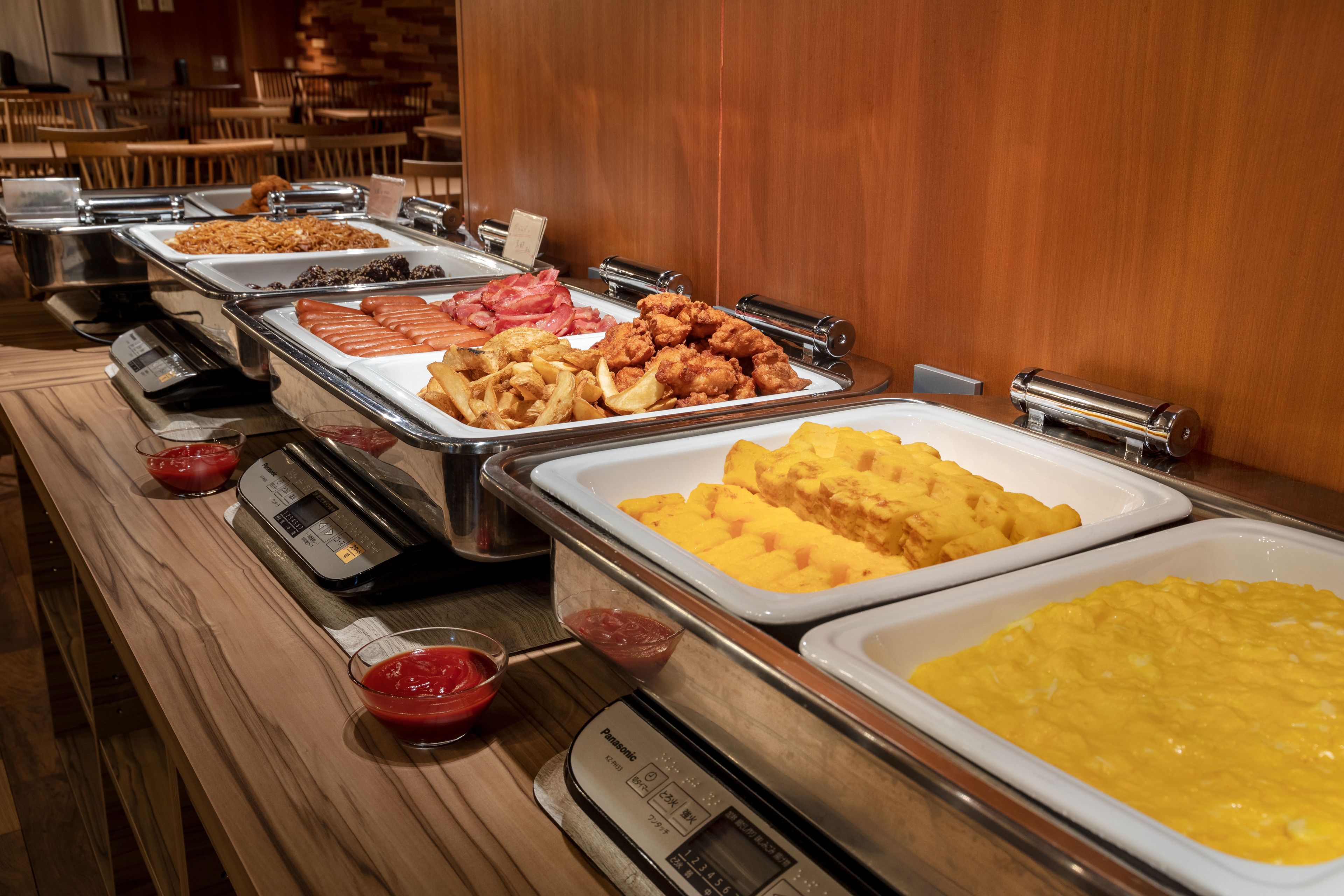 Un bufé con diversas opciones de comida, incluyendo pollo frito, gofres y huevos revueltos.