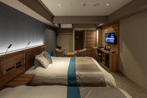 Una habitación de hotel moderna con una cama grande, un escritorio, un televisor y un baño.