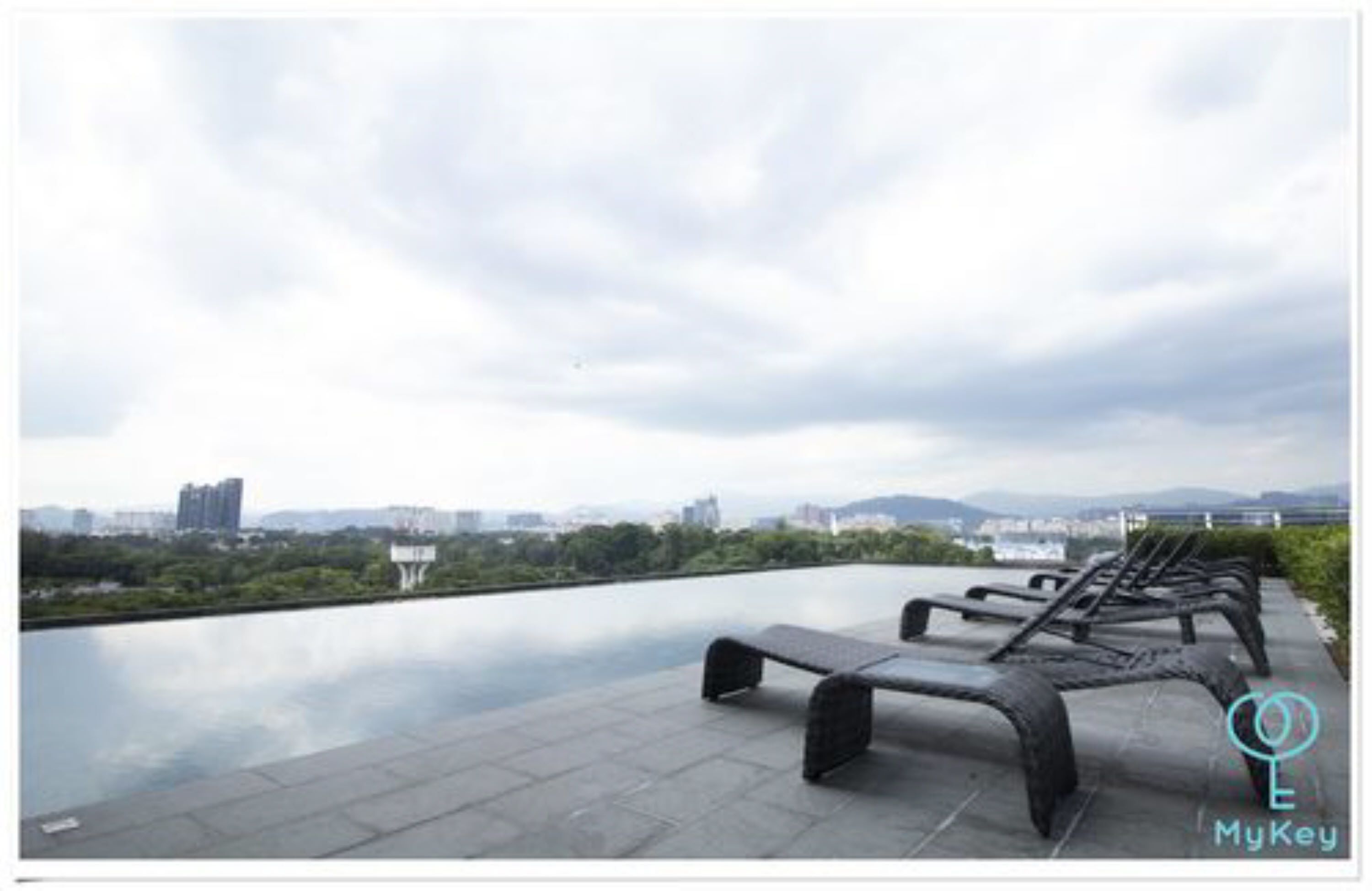 A rooftop terrace with a view of a cityscape and a body of water.