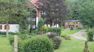 A traditional house with a garden, a stone pathway, and a wooden fence.