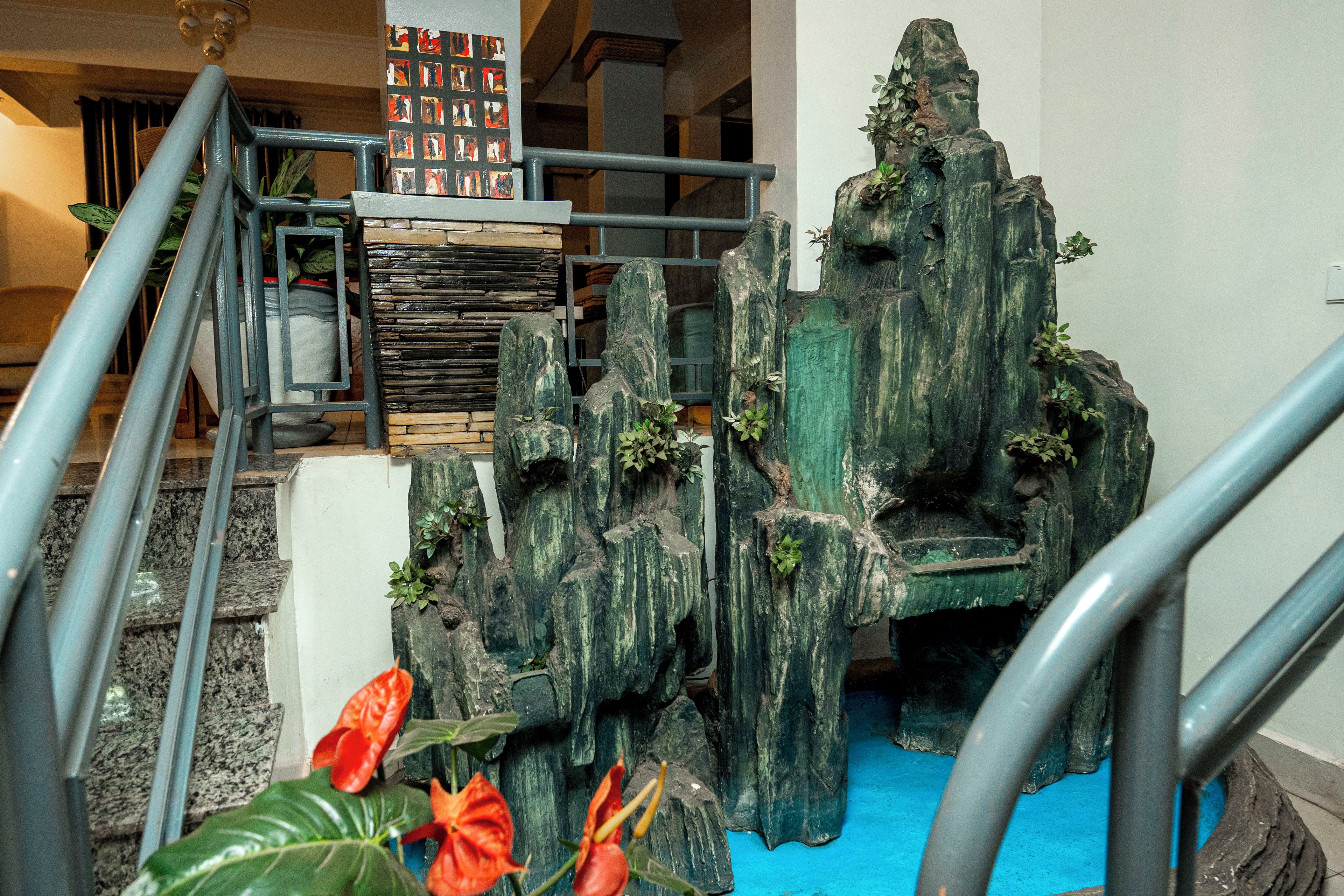 A staircase with a rock formation and a blue pool at the bottom.