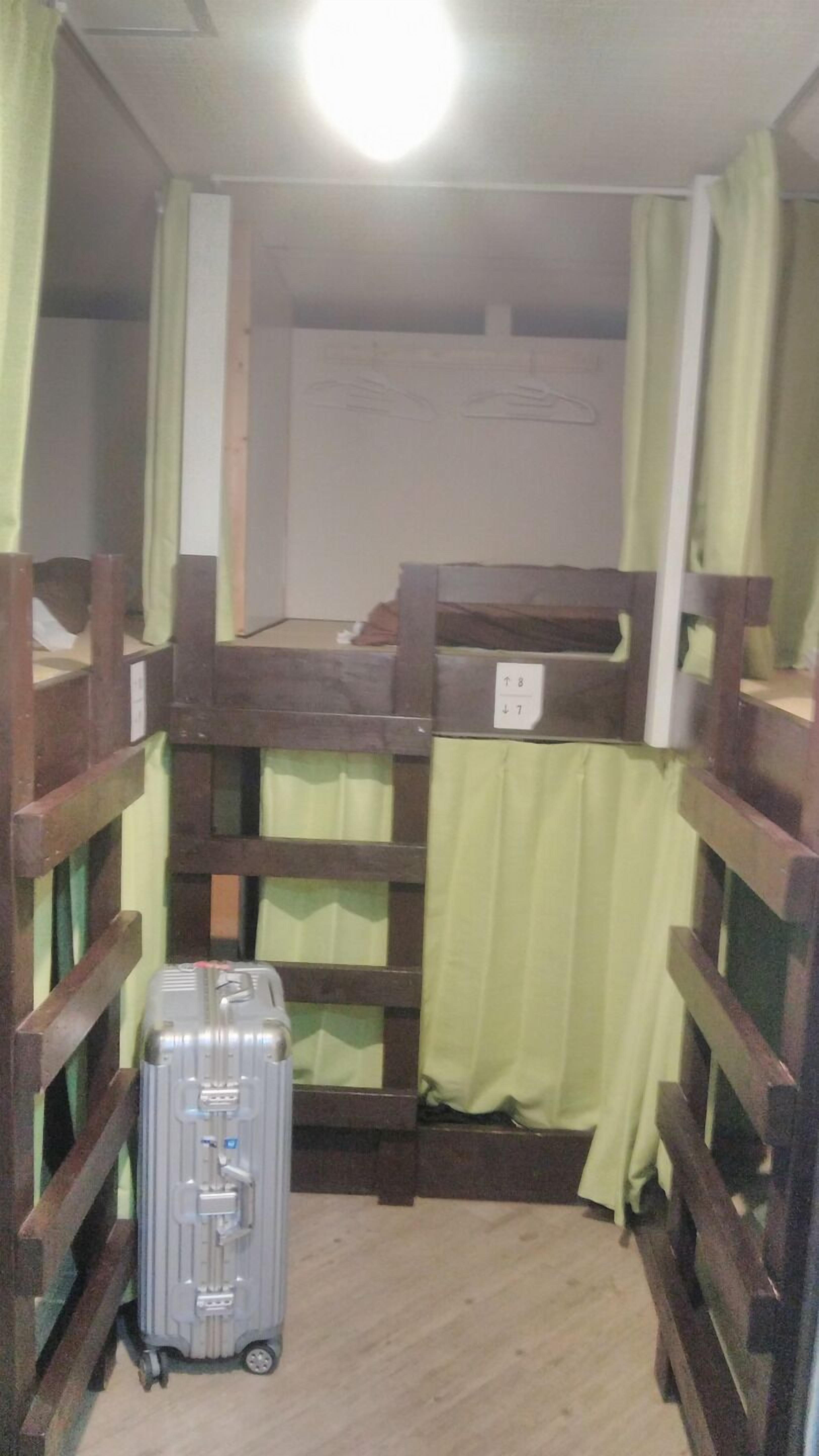 A bunk bed room with a suitcase on the floor.
