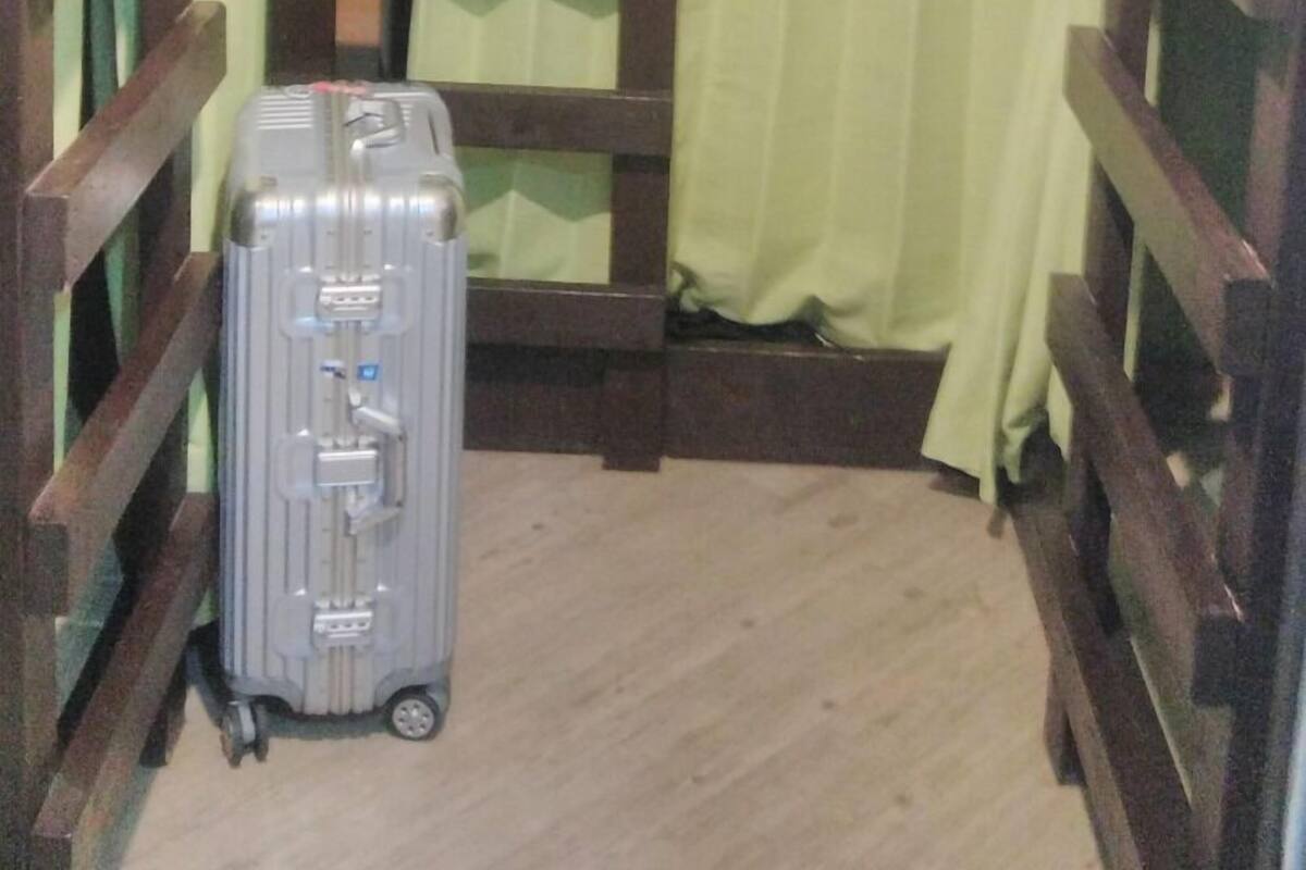 A bunk bed room with a suitcase on the floor.