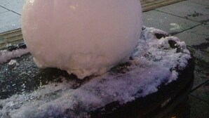A snowman on a sidewalk with a building in the background. - Guest House Asahikawa Ride - Hostel (Asahikawa)
