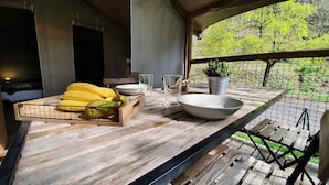 A wooden table with a fruit basket, bowls, and glasses. - Camping les Vernières (La Bourboule)