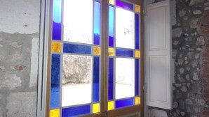 A door with stained glass panels and a white door beside it. - Jackotel Orleans (Orléans)
