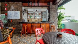 A bar area with stools, a table, and a menu board. - Stay Malate Hostel (Manila)