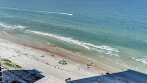 A beach with clear water, a sandy shore, and a few umbrellas.