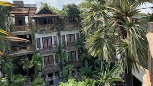 A multi-story building with balconies, surrounded by lush greenery and palm trees. - Little Prince Resort & Spa (Siem Reap)