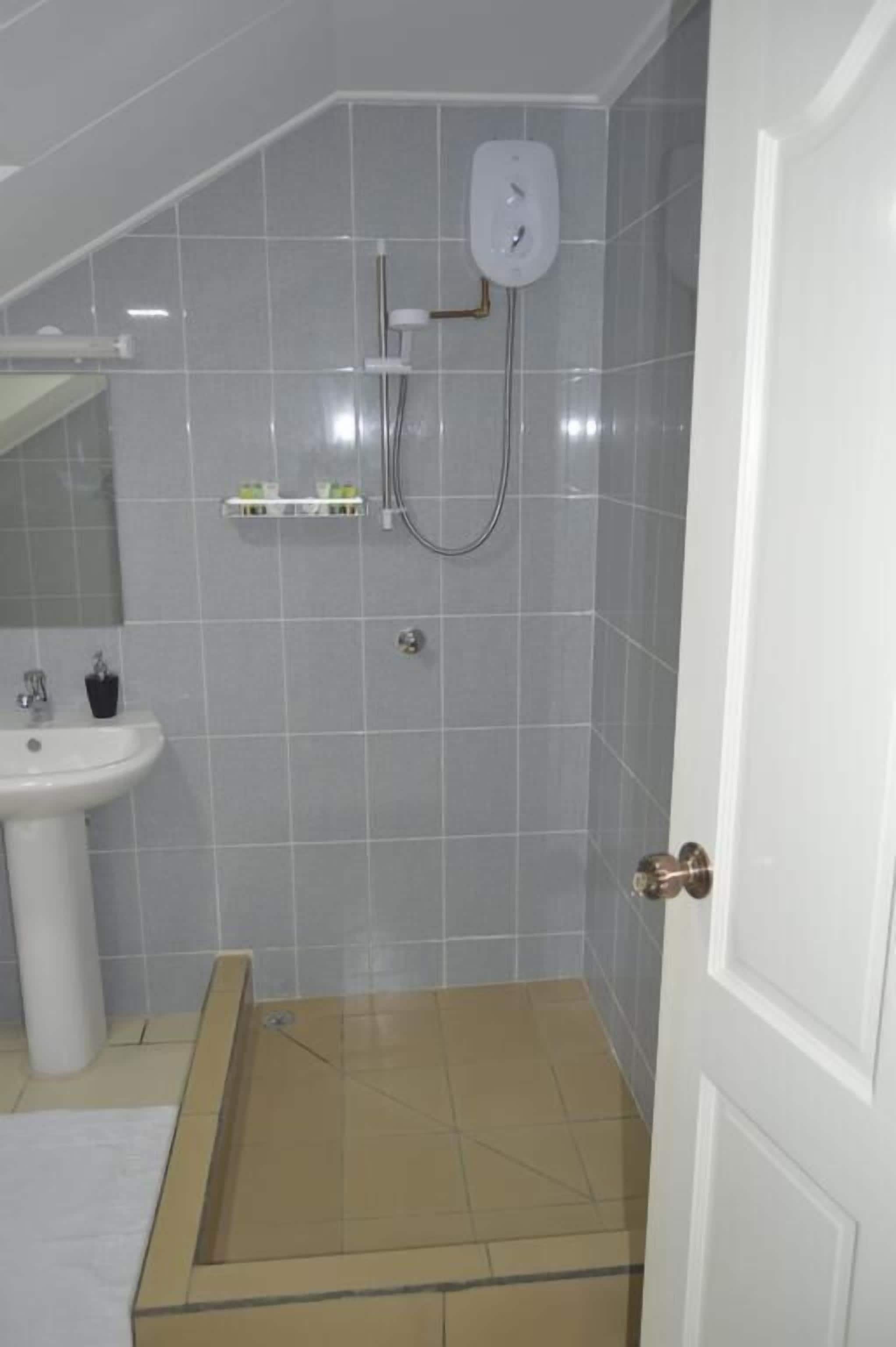 Un bagno con doccia, lavandino e WC.