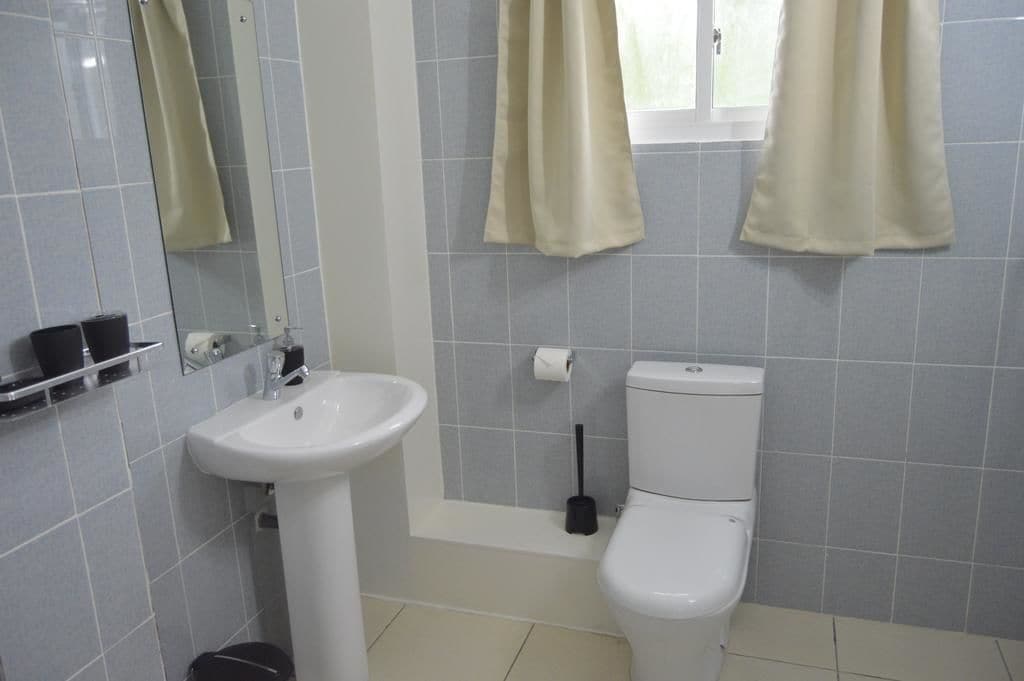 Un baño con lavamanos, inodoro y bañera blancos.