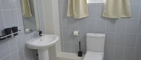 A bathroom with a white sink, toilet, and bathtub.