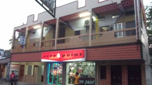 A building with a 'zero point' sign, featuring a storefront with glass doors and a bicycle parked outside. - Azmiry Residential Hotel (Kushtia)